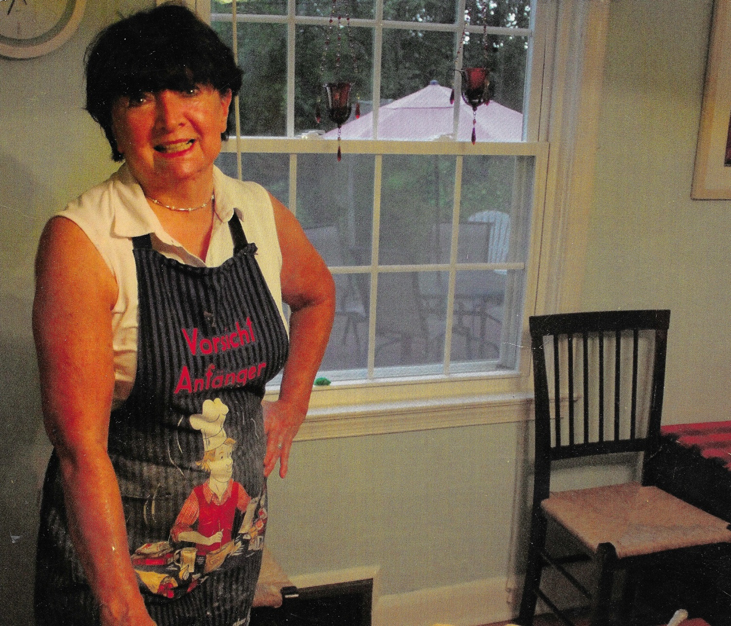 Dorothy Addison Hosmer standing in her kitchen wearing an apron